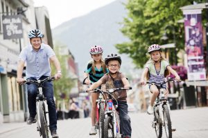 Familie på sykkeltur i Lillehammer sentrum.